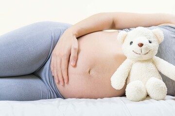 Pregnant woman lying on bed holding her belly,expecting baby.Rest and communication with an unborn child.