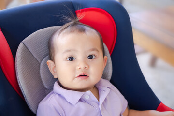 Fototapeta na wymiar Little boy 1 year old baby with Mouth-stained candy sitting on car seat. authentic cute baby asian thailand. mother and child concept.