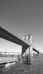 Black and white wide angle picture of Brooklyn Bridge, New York City, US.
