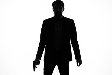 shadow of a man with a gun in his hands aiming detective crime light background