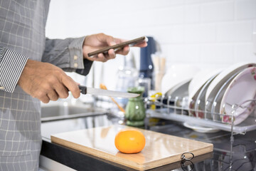 Blurred man asian cooking in kitchen of home He hands cutting vegetables and cutting fruit in the kitchen   to great hand on microwave in kitchen blurred background
