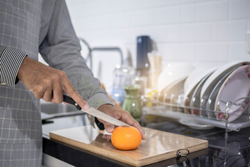 Blurred man asian cooking in kitchen of home He hands cutting vegetables and cutting fruit in the kitchen   to great hand on microwave in kitchen blurred background
