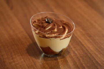 Tiramisu in glass on vintage table, traditional coffee flavored Italian dessert made of ladyfingers and mascarpone