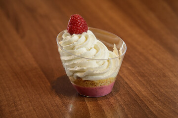 Raspberry dessert with whipped cream in a glass