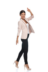 Obraz premium happy young businesswoman in pink jacket smiling and military saluting