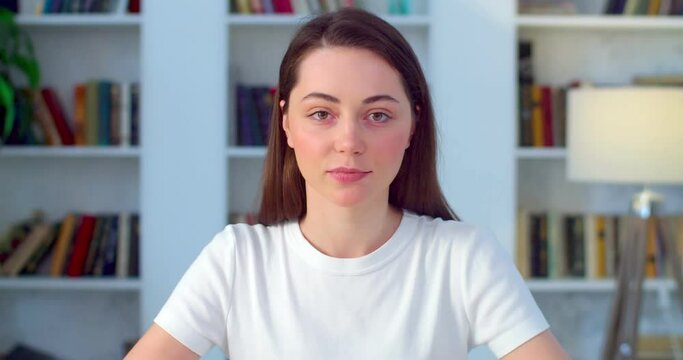 Young natural woman job applicant manager talks with online client during distance interview, webcam front view. Female student girl looks at camera making conference video call slow motion. Telework 