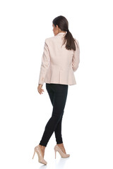 back view of young businesswoman in pink jacket looking to side