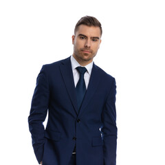 confident elegant man in navy blue suit holding hand in pocket