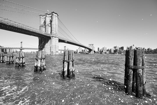 Black and white picture of Brooklyn Bridge with wave splash droplets, New York City, USA.
