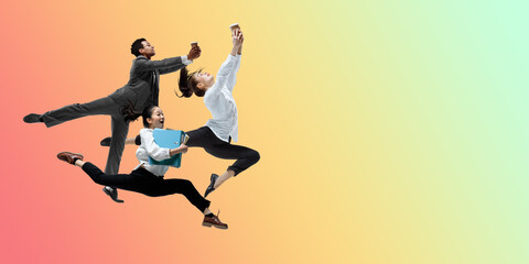 Fototapeta na wymiar Inspired. Happy office workers jumping and dancing in casual clothes or suit isolated on gradient neon fluid background. Business, start-up, working open-space, motion, action concept. Creative