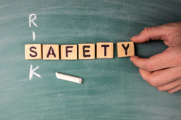 Risk and Safety concept. Text from letters of the wooden alphabet on a green chalk board