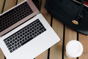 The laptop with the woman's purse and coffee outdoors