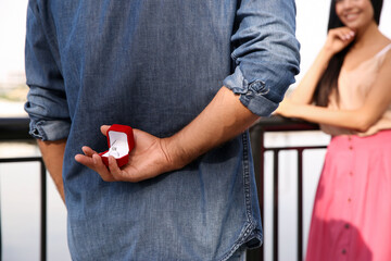 Man with engagement ring making proposal to his girlfriend outdoors, closeup