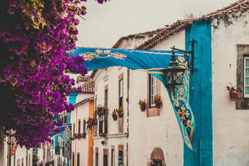 OBIDOS, PORTUGAL - 08-09-2020 : Souvenir shops and colorful narrow streets of the medieval portuguese city of &Oacute;bidos, a tourist attraction in central Portugal. famous destination for its architecture