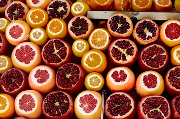 Pomegranates, cut lemons showing their segments with intense yellow and red colors