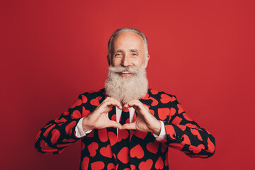 Photo of romantic bearded old man fingers show heart figure wear heart print suit tie isolated red...