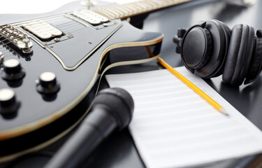 composing and music writing concept - close up of bass guitar with music book, microphone and...