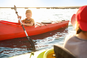 Little children kayaking on river. Summer camp activity