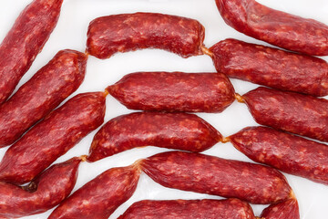 Background of small thin dry cured sausages, fragment top view