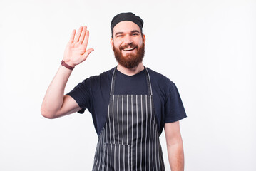 Naklejka premium Photo of chef man saying HELLO gesture over white background.