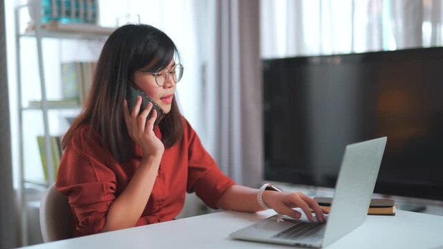 The phone rang while working seriously in the comfortable living room. Friends ask her to hang out after finish working with a shyness and a big smile. Telephone interruption while working at home.