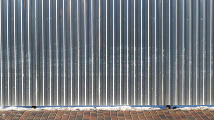 silver metal dirty gray fence on the street in the city in winter