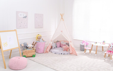 Cute child's room interior with toys, modern furniture and play tent © New Africa