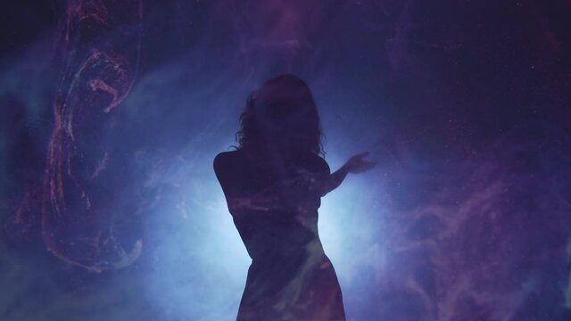 Silhouette woman. Tranquility dance performance. Magic spirituality. Graceful lady moving in haze shadow defocused spot neon light curved lines dark background slow motion copy space.