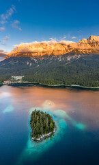 Aerial drone shot of Alpenglow with fog on Zugspitze by Eibsee lake in Germany