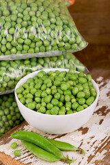 fresh green pea in bowl on wooden background