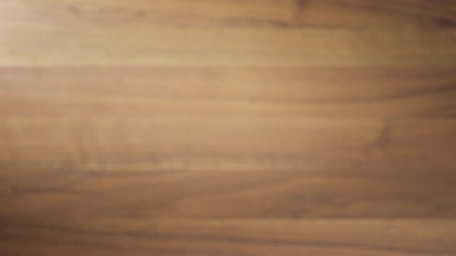 Hand holding vintage photo camera in front of wooden background