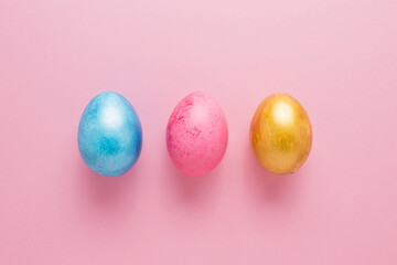 Multi-colored Easter eggs on a pink isolated background. Easter is a bright holiday.