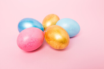 Multi-colored Easter eggs on a pink isolated background. Easter is a bright holiday.