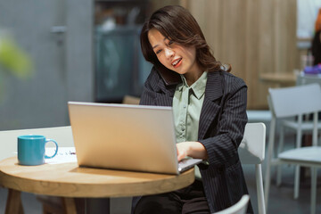 Cheerful young businesswoman working at the coffee shop