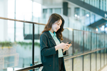 Fototapeta na wymiar Portrait of a young Asian female director holding a phone