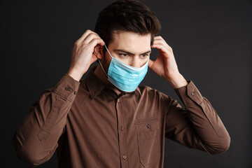 Obraz premium Focused handsome young man posing in protective mask