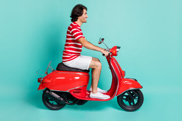Fototapeta na wymiar Profile side view portrait of handsome cheerful guy driving moped spending weekend isolated over bright green turquoise color background