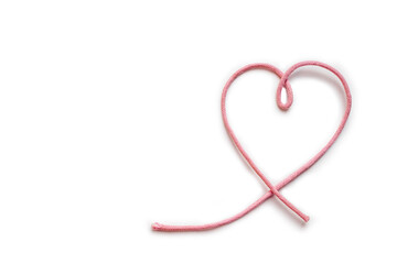Ribbon pink heart with white background and copy space. Tiny heart shape pink cord. Happy Valentine's Day, Valentines Card. Simbol of Love. Top view, close up.