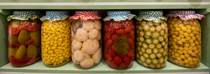 Lots of colorful pickles in bottles, jars of pickles, different pickled vegetables ...