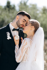 Fashion and stylish close-up portrait of beautiful newlyweds on a walk near the rocks