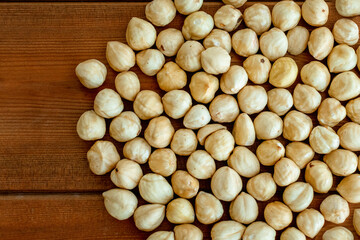 Scattered on the table roasted hazelnuts on a wooden table. Peeled roasted hazelnut