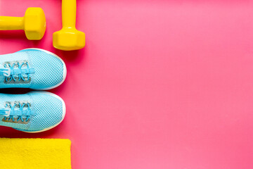 Fitness and gym equipment with sneakers and dumbbells. Sport background