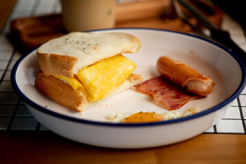 Egg sandwich served with sausage and bacon.