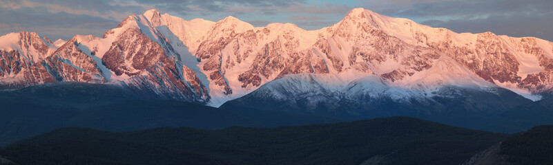 Naklejka premium Panorama. Mountain peaks in dawn light.