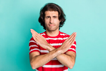 Portrait of handsome sullen brown-haired guy showing ban sign prohibition isolated over bright...