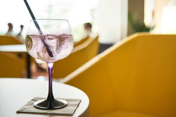Glass of cold refreshing gin tonic cocktail on table in summer.