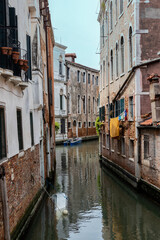Fototapeta na wymiar Venetian canal with a sunken boat. view from the bridge to the connection of two channels