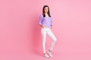 Fototapeta na wymiar Full size photo of optimistic girl stand wear lilac sweater trousers sneakers isolated on pink color background