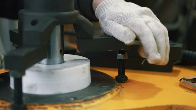 The mechanic tightens the nut. He attaches the boring shaft.
