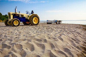 Tractor with trailer for transport boats on the sandy beach